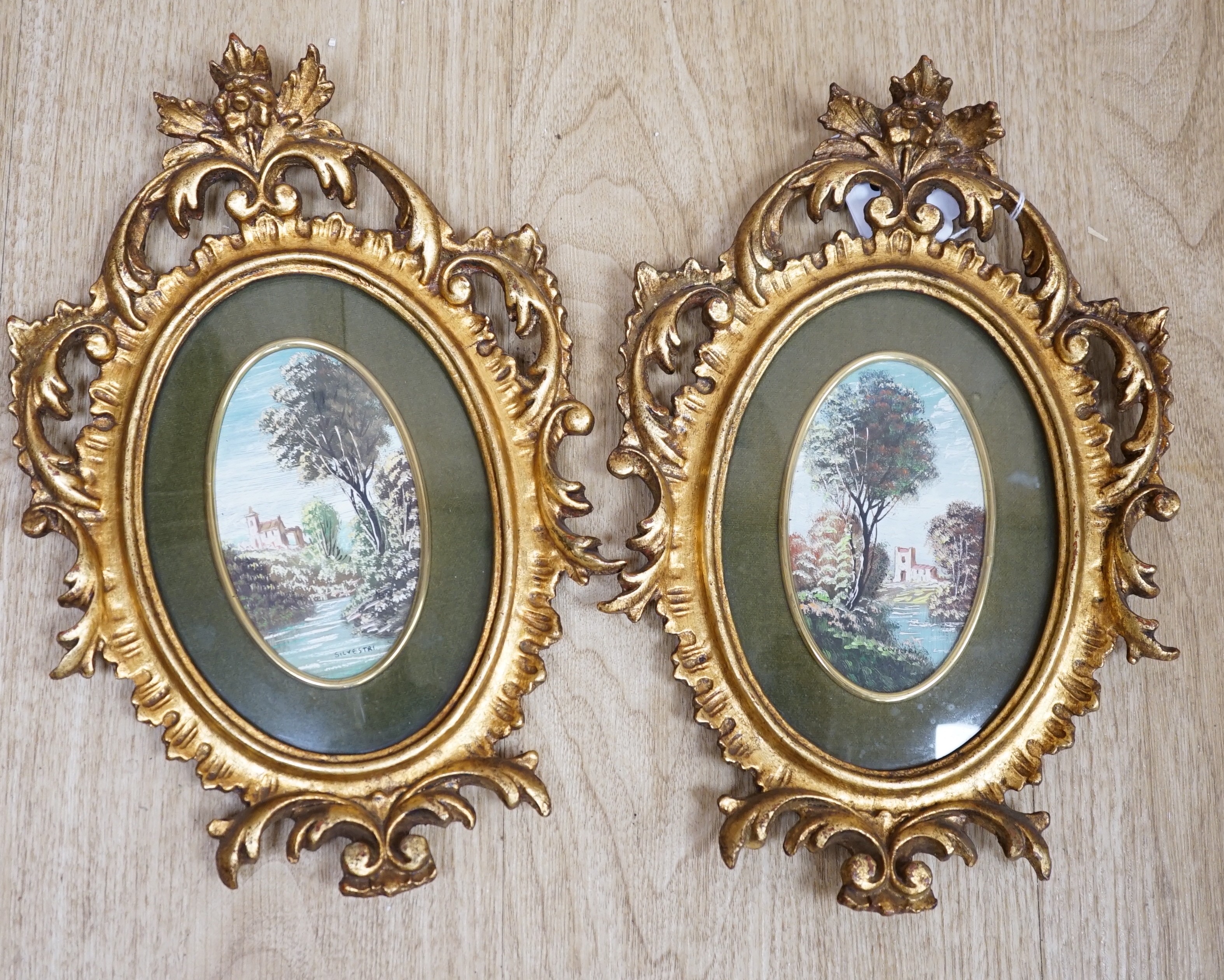 A pair of miniature Italianate landscapes, with pierced, carved oval giltwood frames. 29cm high overall